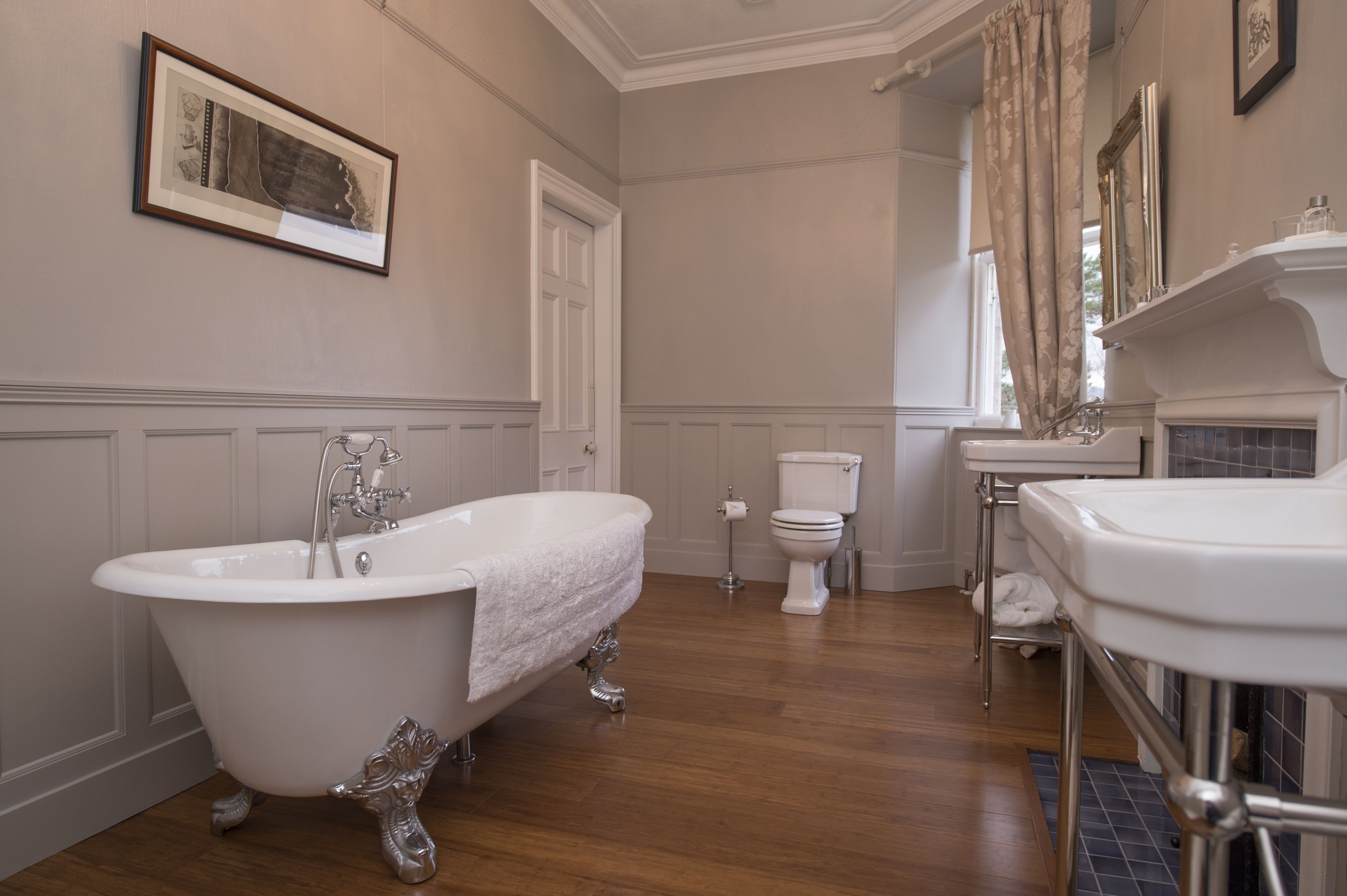 A bathroom with a clawfoot bathtub, a toilet, and a sink.