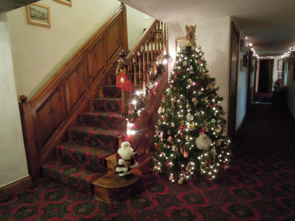 A staircase with a Christmas tree decorated with lights and ornaments.