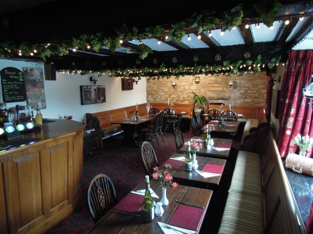 A restaurant with wooden tables, chairs, and a bar area.