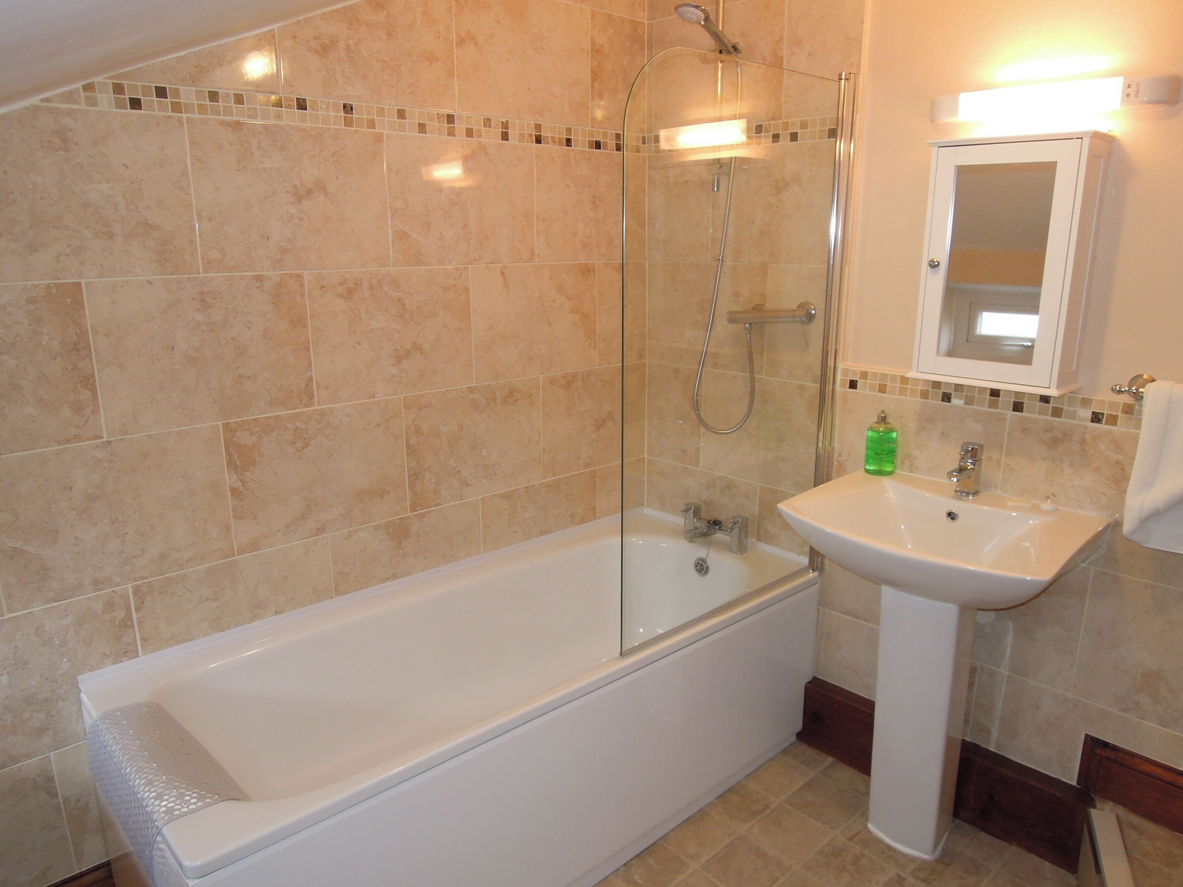 A bathroom with a bathtub, shower, and sink.