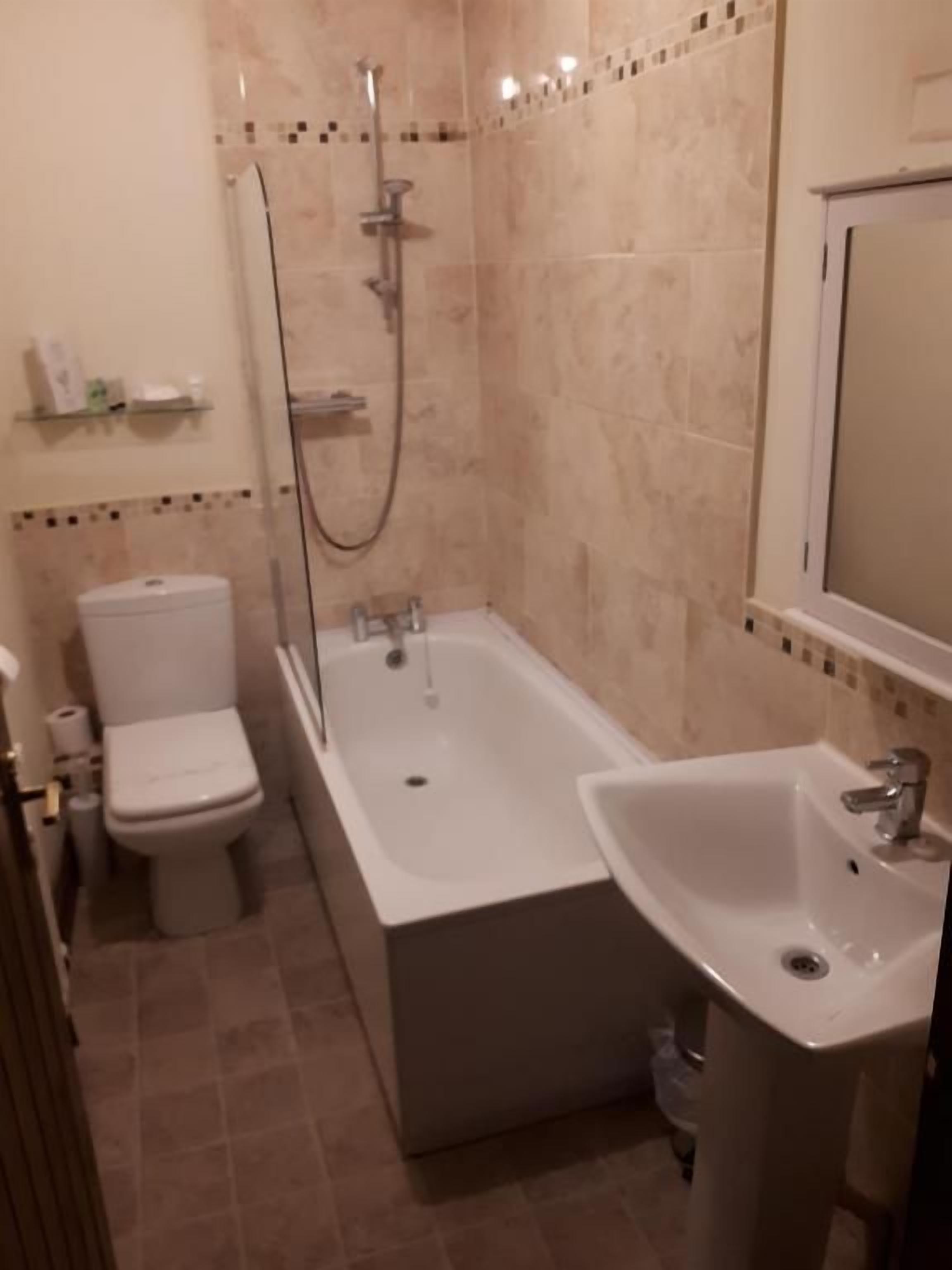 Un baño con bañera, inodoro y lavabo.
