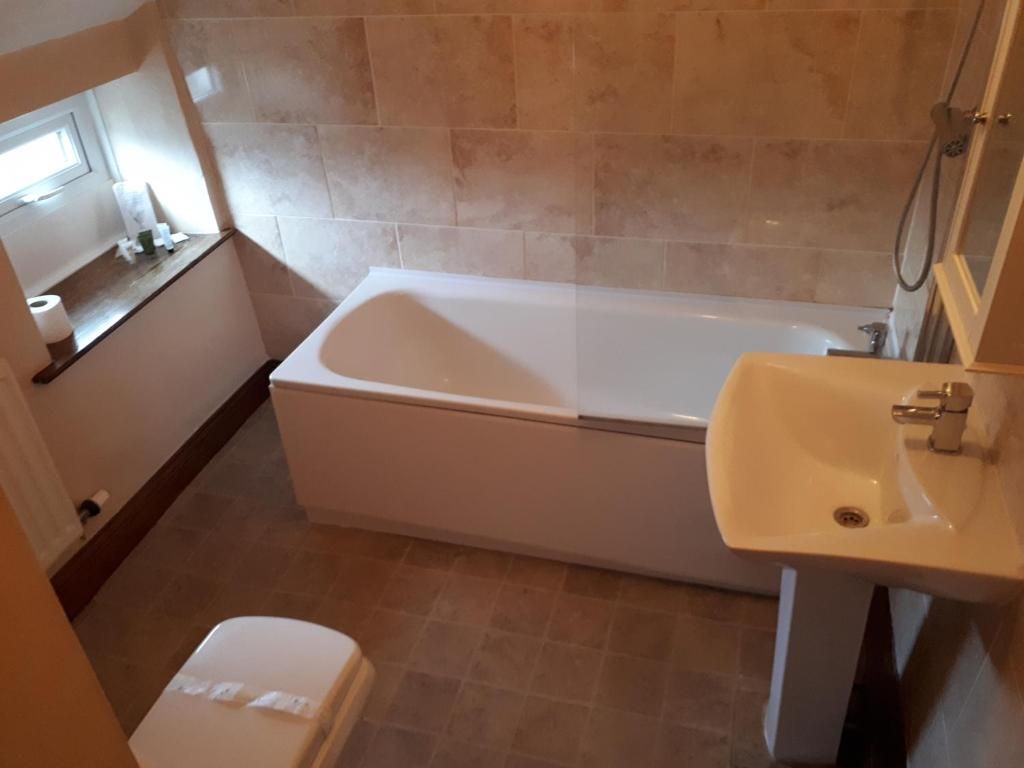 A bathroom with a bathtub, a toilet, and a sink.
