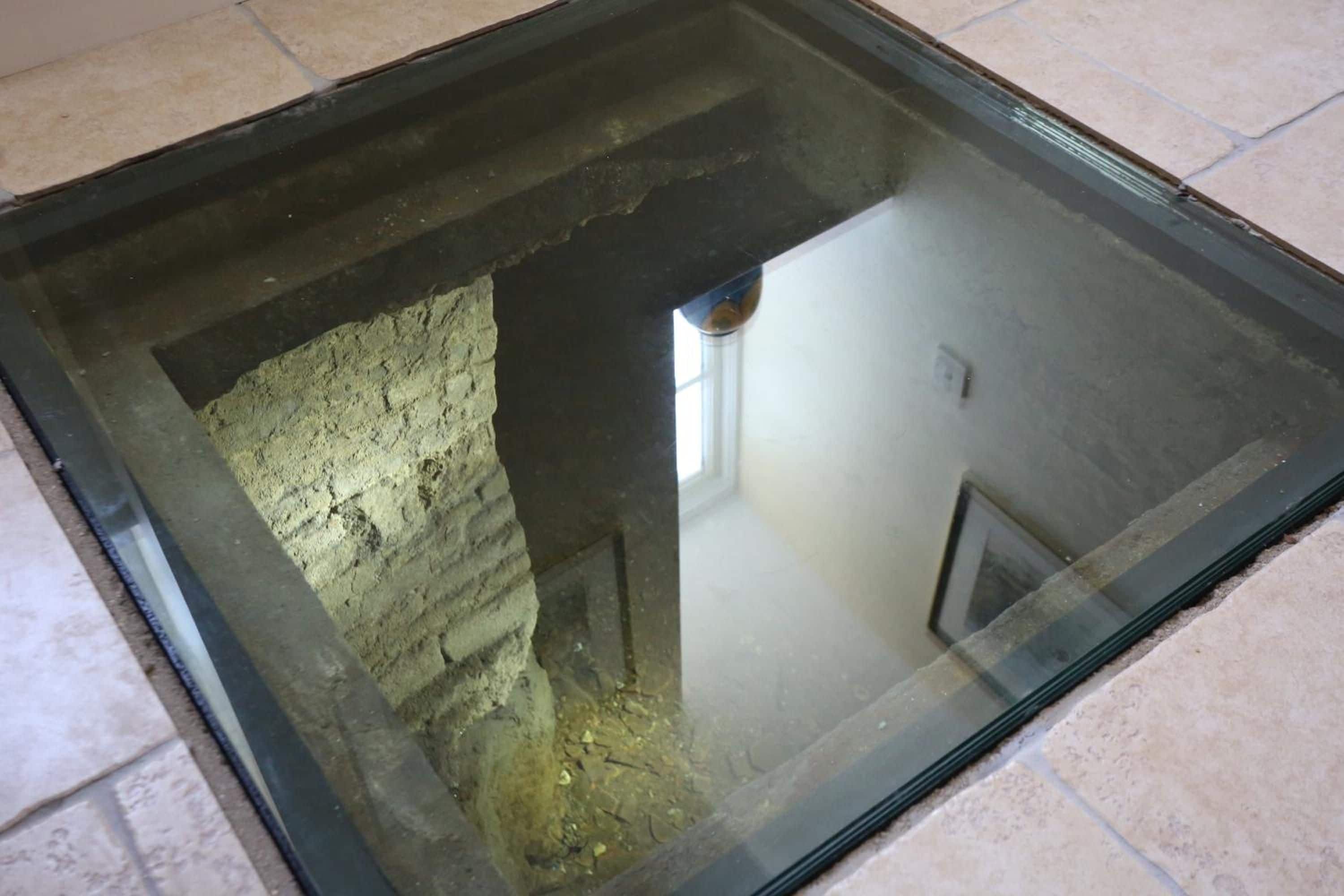 Une lucarne offrant une vue sur une construction en briques et une fenêtre.