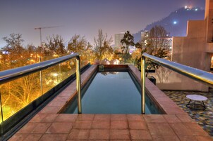Una piscina al aire libre, sombrillas, tumbonas