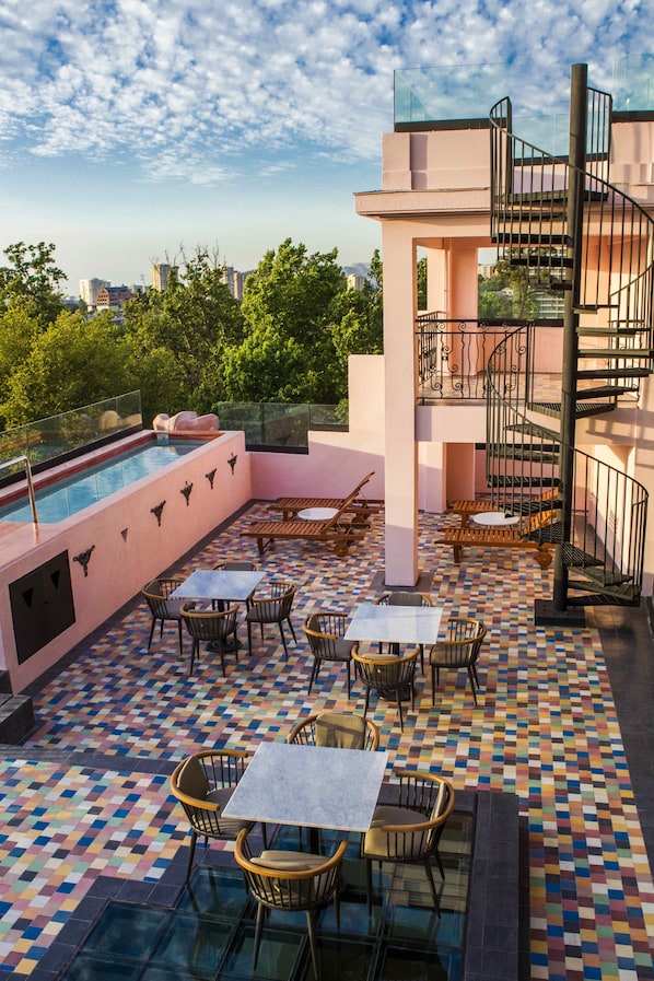 Un espace piscine sur le toit, doté d’un coin salon extérieur et d’un escalier en colimaçon.