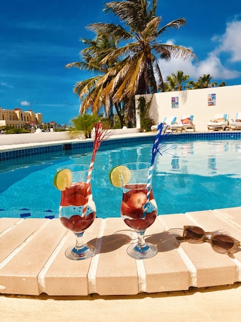 Una piscina al aire libre, sillones reclinables de piscina