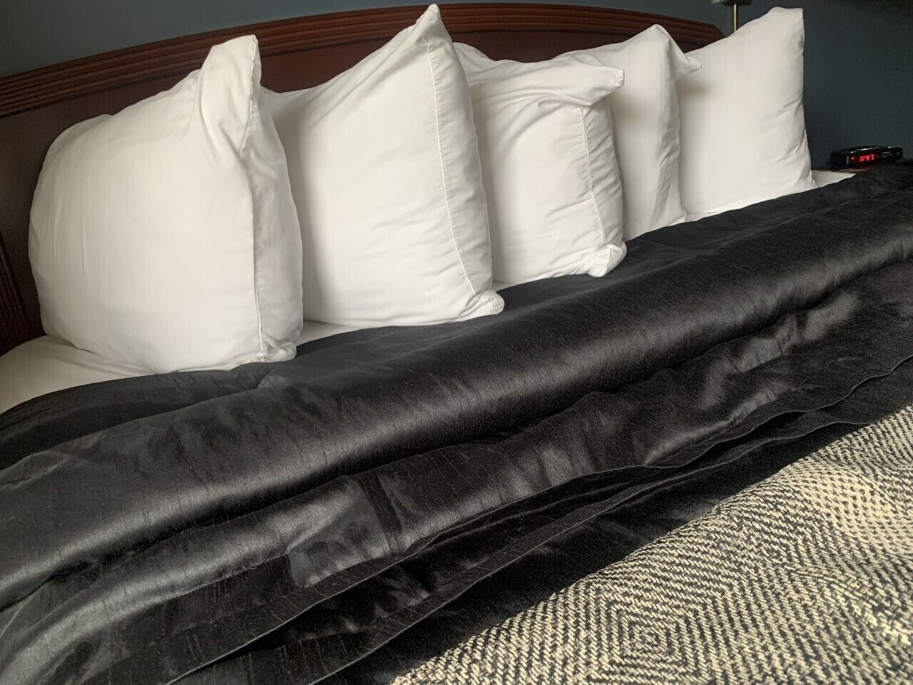 Un letto con cuscini bianchi e una coperta nera.
