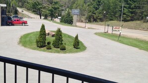 A parking lot with a sign for Bancroft Inn Suites, surrounded by trees and a hilly landscape.