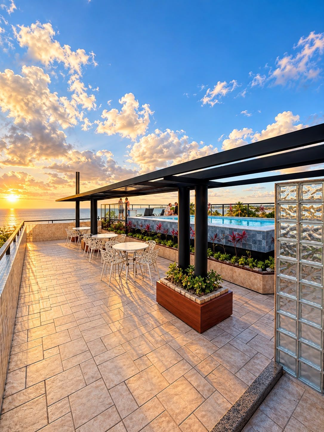 Terraço no telhado com área de estar ao ar livre, piscina e vista para o oceano ao pôr do sol.