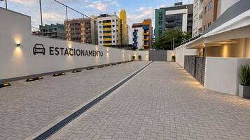 A paved outdoor area with a car icon and the word 'ESTACIONAMENTO' indicating a parking area.