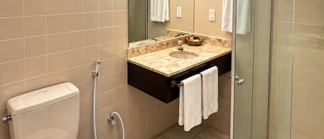 A modern bathroom with a toilet, sink, and glass-enclosed shower.