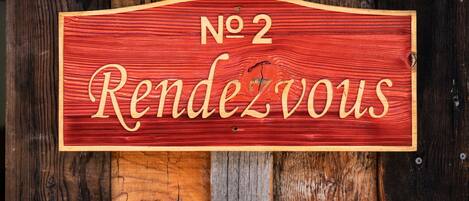 A wooden sign with "No 2" and "Rendezvous" written on it.