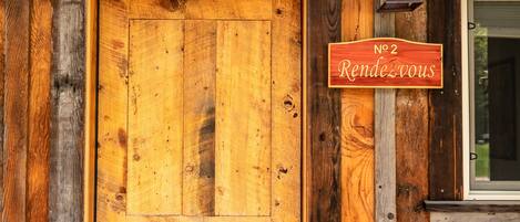 Una puerta de madera con un letrero que dice 'No 2 Rendezvous' y una pequeña ventana encima.