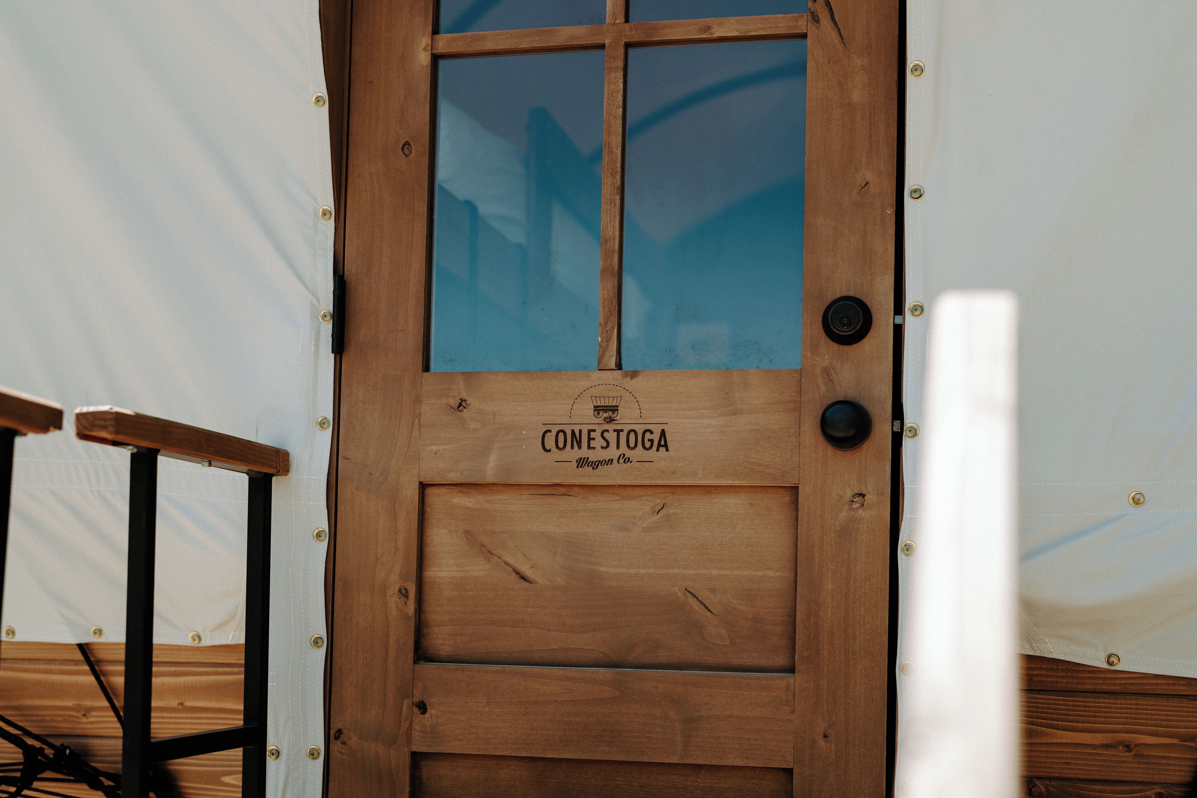 Eine Holztür mit dem Schriftzug "CONESTOGA Wagon Co." und einem Fenster.
