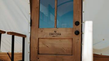 Eine Holztür mit dem Schriftzug "CONESTOGA Wagon Co." und einem Fenster.