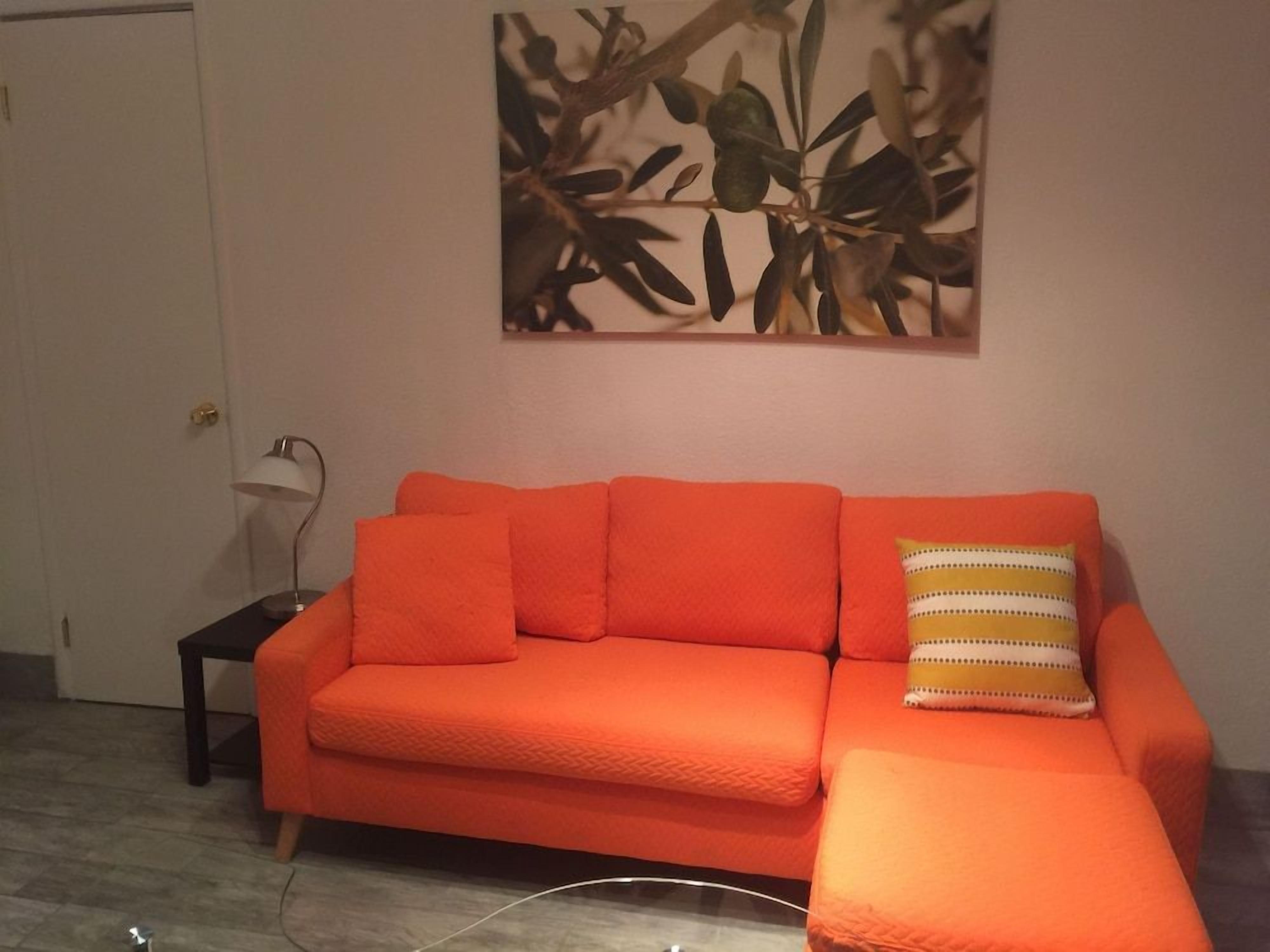 Una habitación con un sofá y una mesita auxiliar.