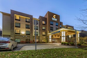 A Comfort Inn & Suites hotel with a modern design, featuring a well-lit entrance and a parking area.