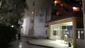 A nighttime view of a building with a sign reading "Regency" and a glass door entrance. - Regency Towers Apartments (Hurghada)
