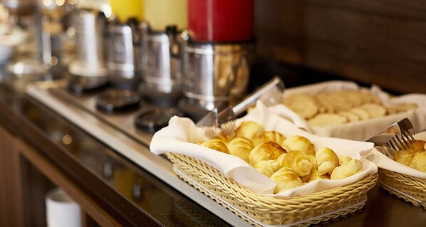 Una mesa de buffet con fuentes de pasteles y salsas.