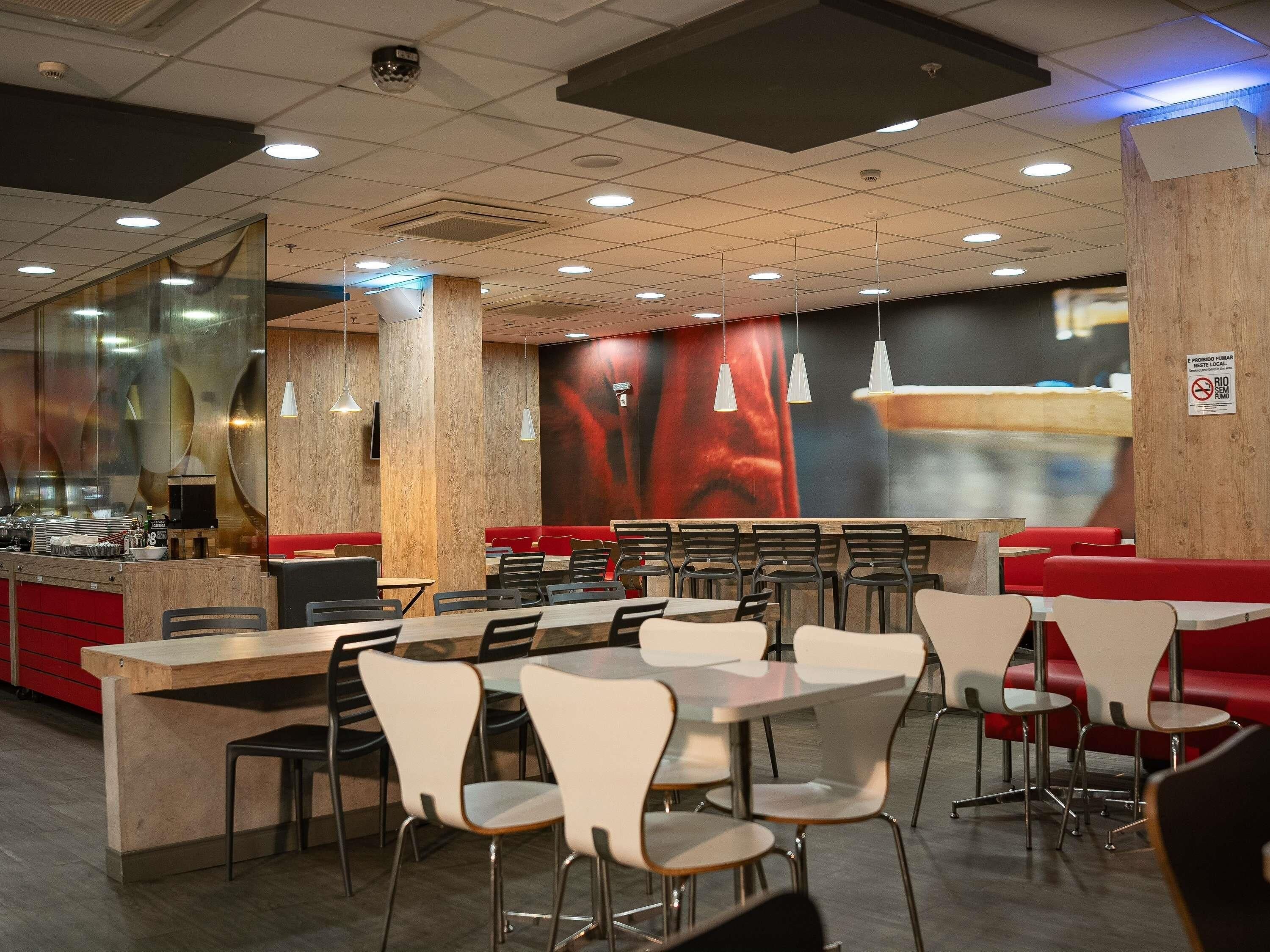 Un interno ristorante con cabine, tavoli e sedie.