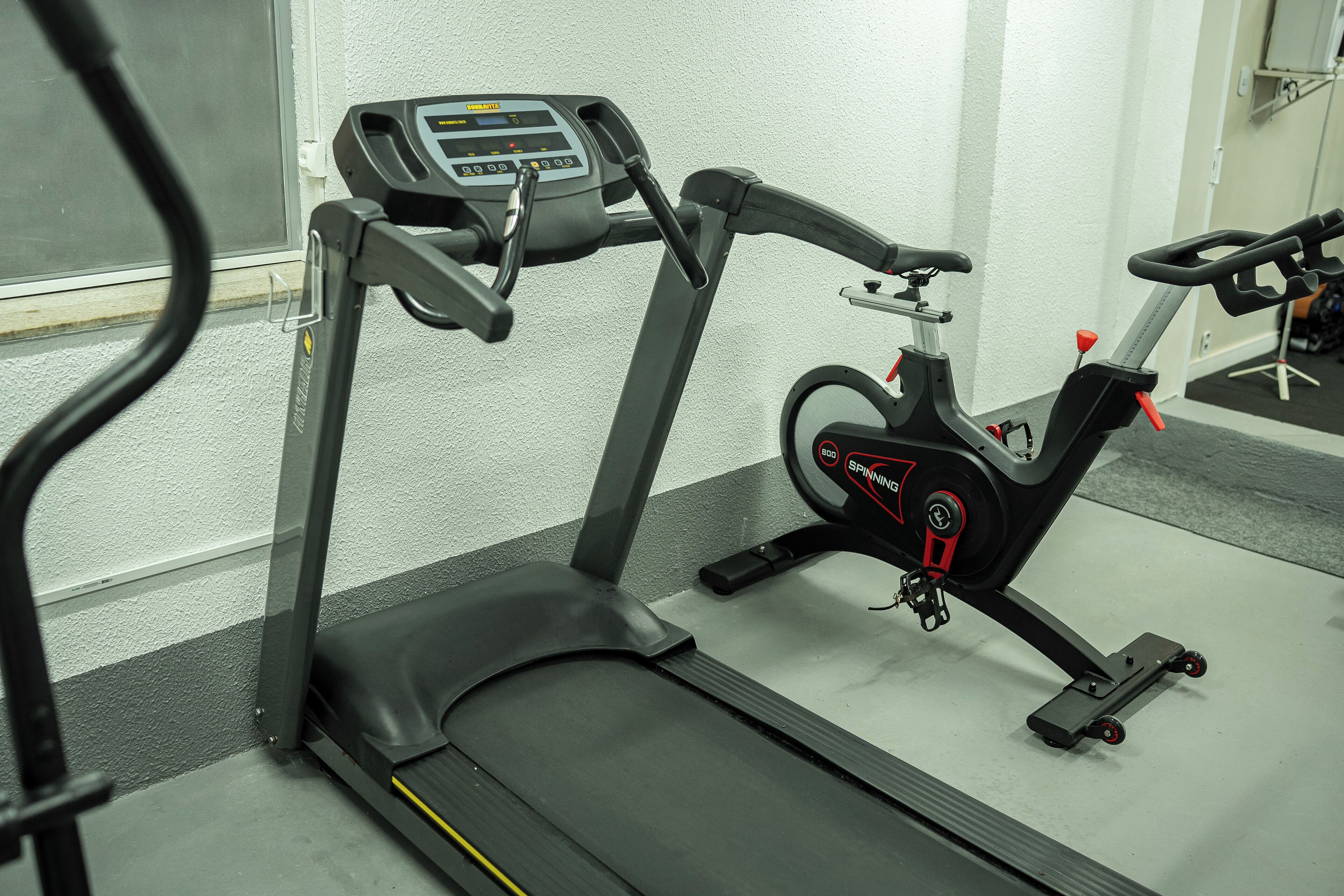 A stationary bike and a treadmill in a gym.