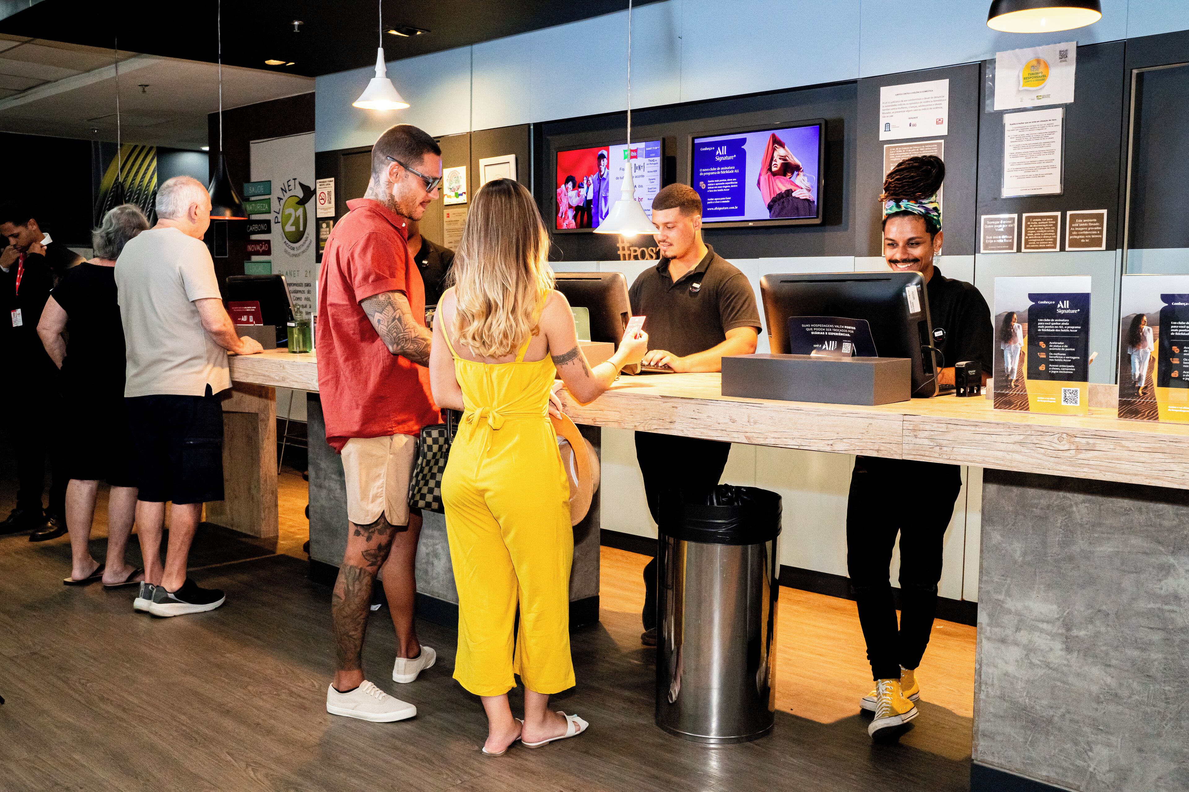 A counter area with a digital menu display, a trash bin, and a seating area with chairs.