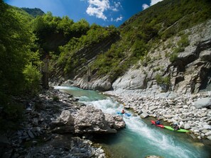 A river with rapids, surrounded by rocky terrain and greenery.