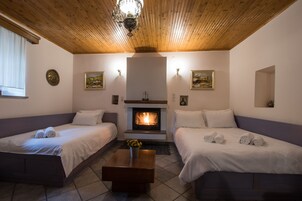 Una habitación acogedora con dos camas, una chimenea y techo de madera.