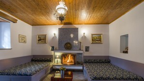 A cozy room with a fireplace, two seating areas, and a chandelier. - Rodami (North Tzoumerka)
