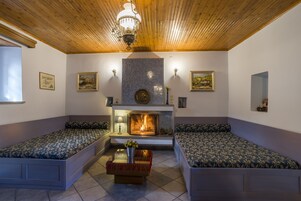 Una habitación acogedora con chimenea, dos zonas de estar y una araña.
