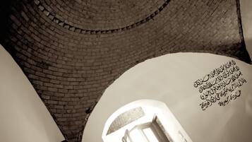 A view of a brick spiral staircase leading upwards, with a door at the bottom.