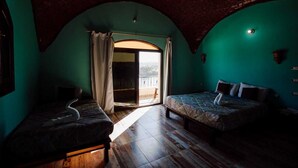 A room with two beds, a large arched doorway, and a view of the outdoors. - Hadouta Masreya - Nubian Guest House (Aswan)