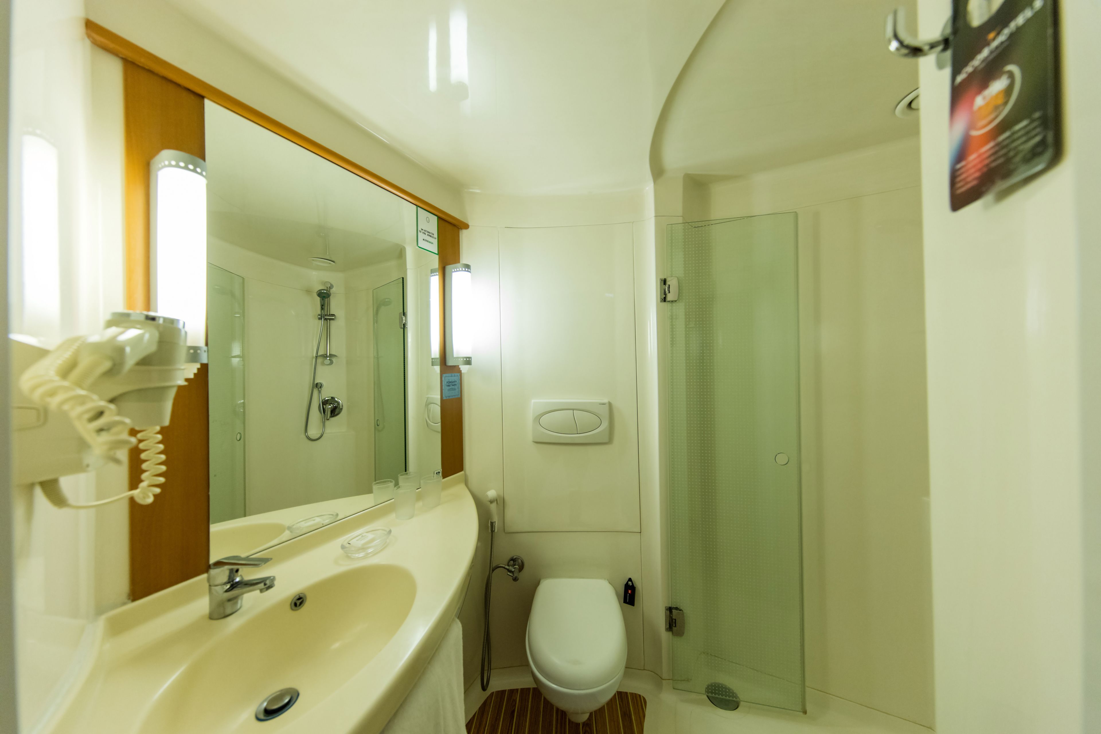 Une petite salle de bain comprenant un lavabo, un miroir, des toilettes et une douche.
