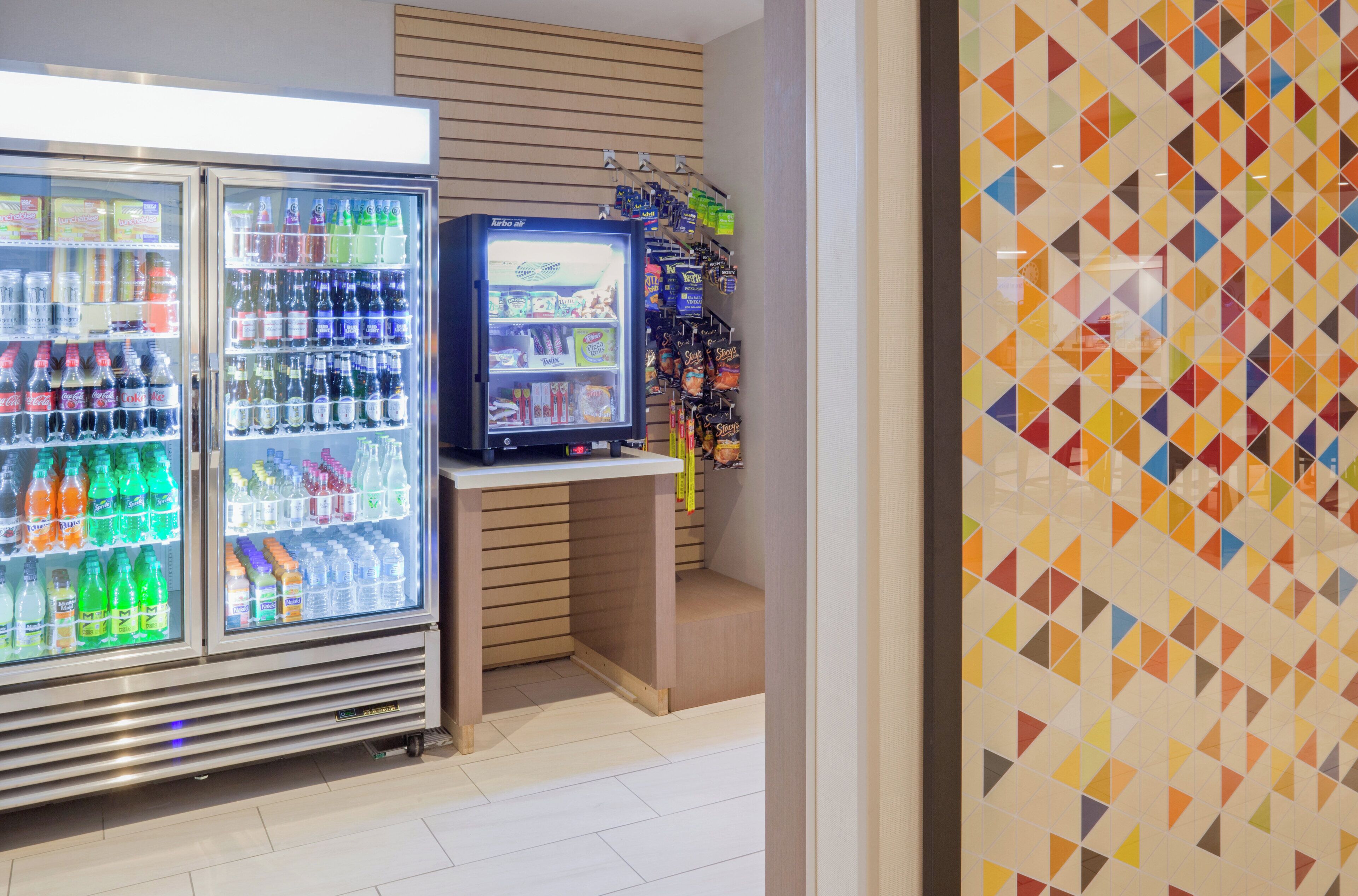 A vending area with various beverage options and snacks, including a refrigerator stocked with sodas and a smaller cooler with snacks.