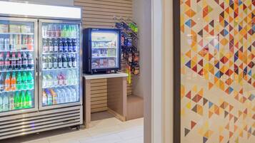 A vending area with various beverage options and snacks, including a refrigerator stocked with sodas and a smaller cooler with snacks.