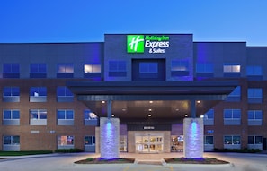 A Holiday Inn Express & Suites building with a brick facade, large windows, and a covered entrance area. - Holiday Inn Express & Suites Des Moines Downtown by IHG (Des Moines)