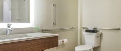 A bathroom with a sink, mirror, toilet, and towel rack.