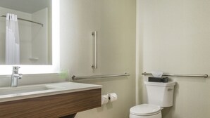 A bathroom with a sink, mirror, toilet, and handrails. - Holiday Inn Express & Suites Clarion by IHG (Clarion)