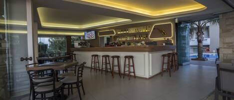 A modern bar area with a central island, bar stools, and a seating arrangement.