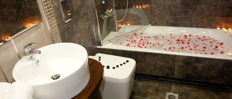 Et badeværelse med badekar, vask og toilet.