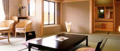 A traditional Japanese room with tatami flooring, a low table, and a futon bed.