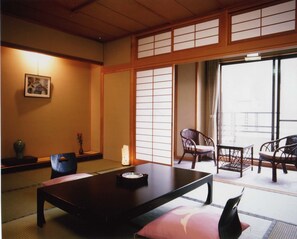 Ein traditioneller japanischer Raum mit Tatami-Böden, einem niedrigen Tisch und verschiebbaren Shoji-Türen.