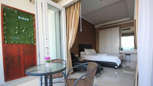 Une chambre d’hôtel avec un lit, une petite table et des chaises, une salle de bain et une vue sur l’extérieur.