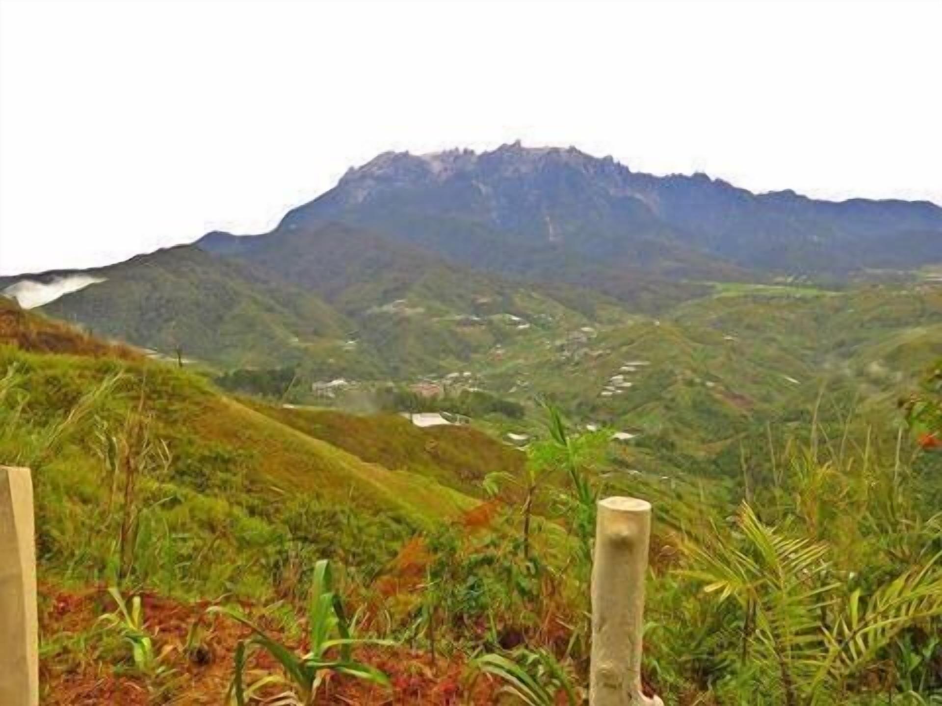 Un paisaje montañoso con vistas a un valle y un pequeño asentamiento.