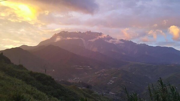 A mountain landscape with a valley and a small settlement.