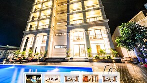 Un hotel de varios pisos con una piscina en primer plano.
