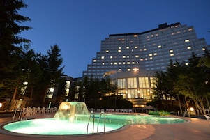 Un hotel con piscina, cascada y un edificio grande con muchas ventanas.