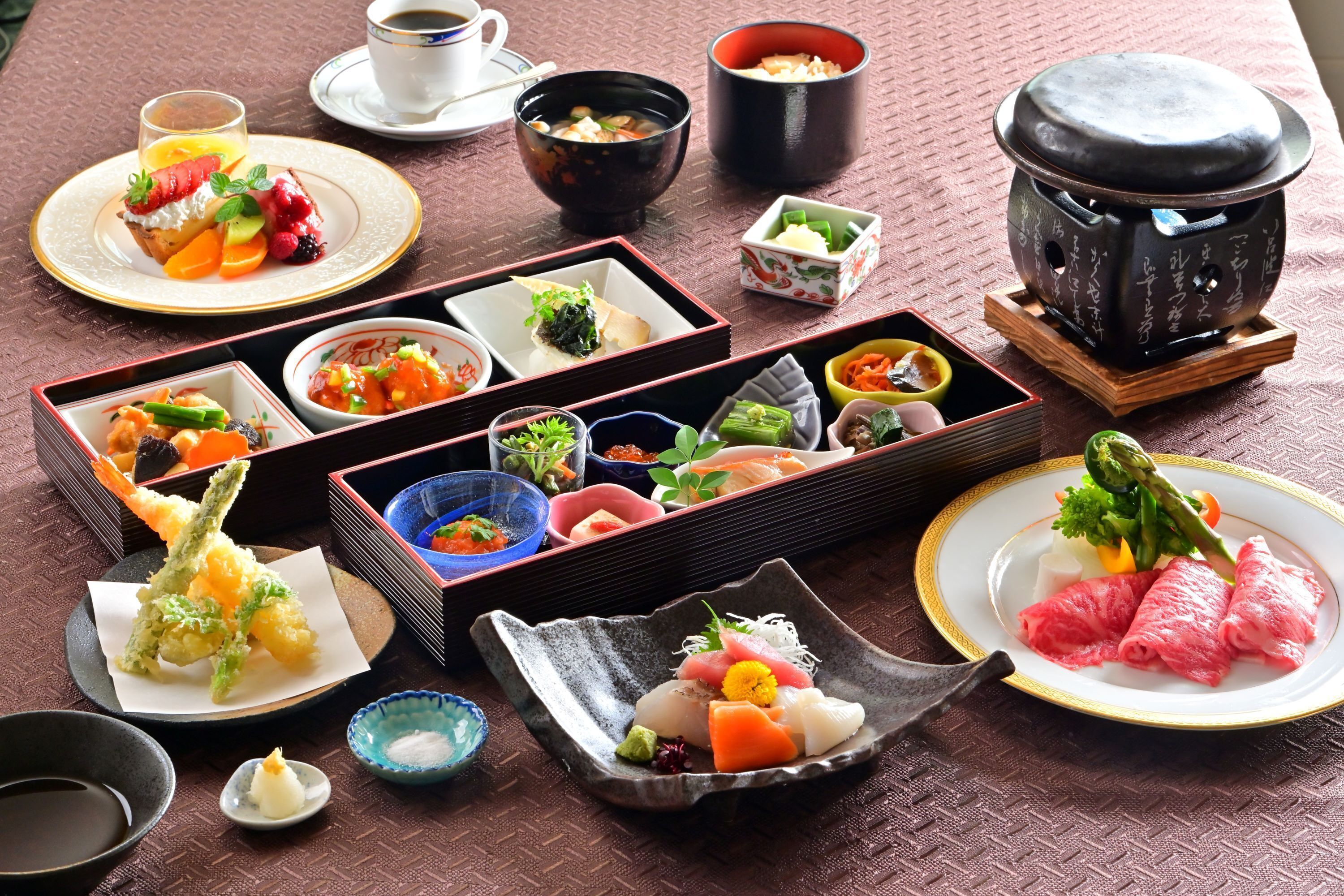 Diverse Japanse gerechten op een tafel gerangschikt, waaronder sushi, tempura en andere lekkernijen, met kleine schaaltjes en borden om te serveren.