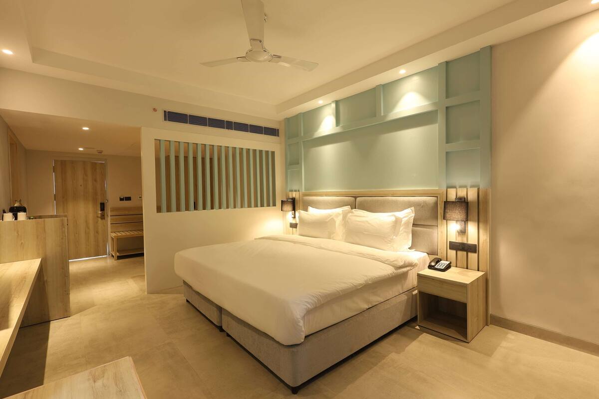 A modern bedroom with a large bed, bedside lamps, and a built-in shelf.