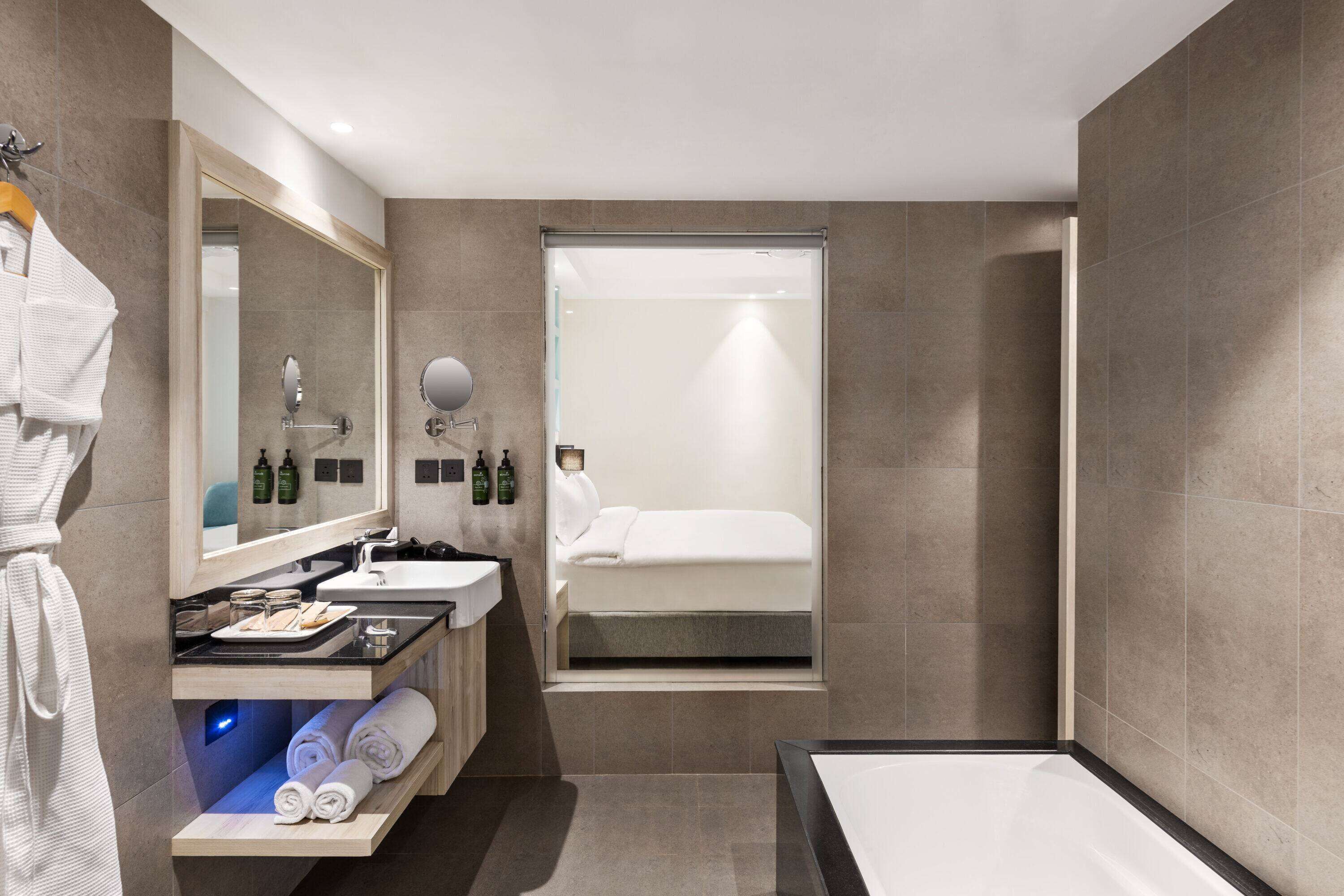 Ein modernes Badezimmer mit einer großen Badewanne, einem Waschtisch mit Spiegel und einer Duschkabine.